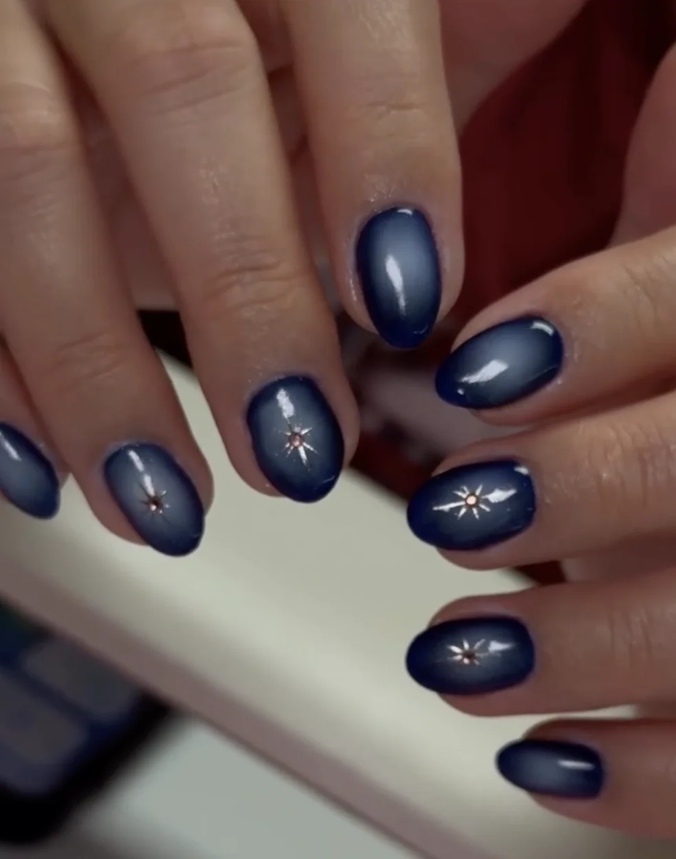 Navy blue nails with gold star accents after transformation