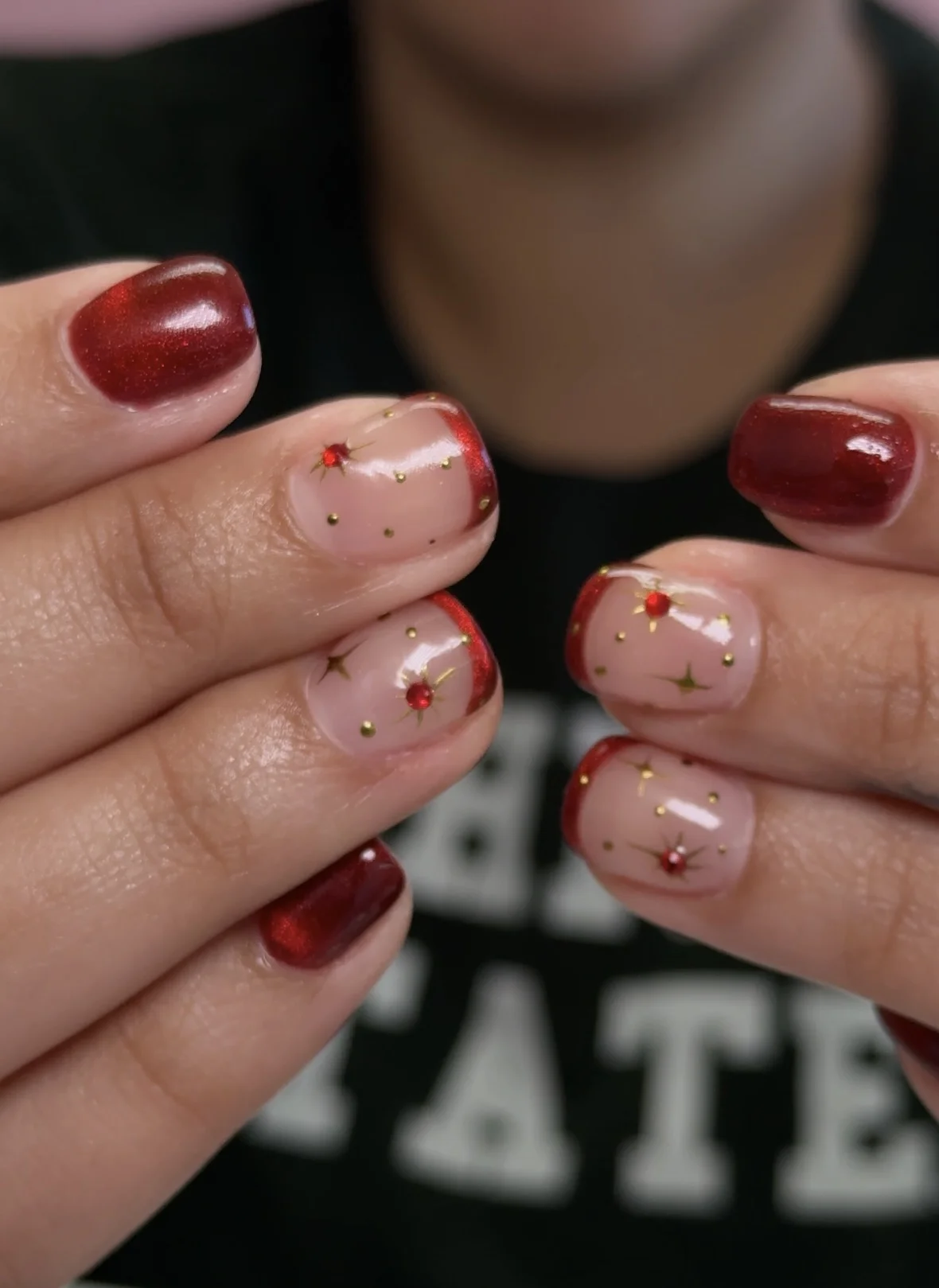 Red holiday nails with gold stars - festive nail art for The Woodlands area