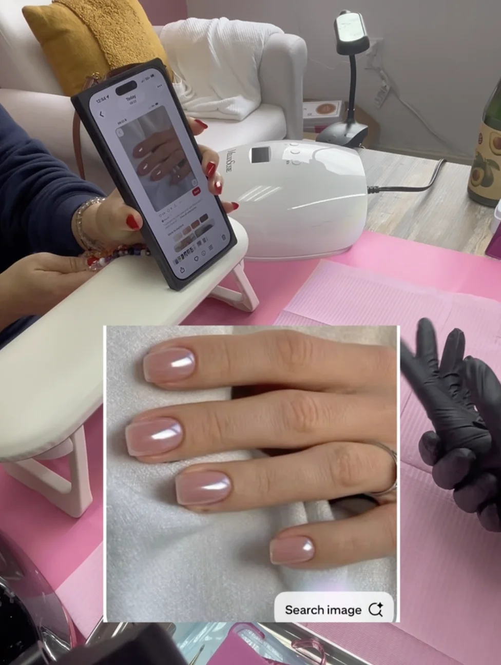 Client with red nails showing pink nail inspiration photo