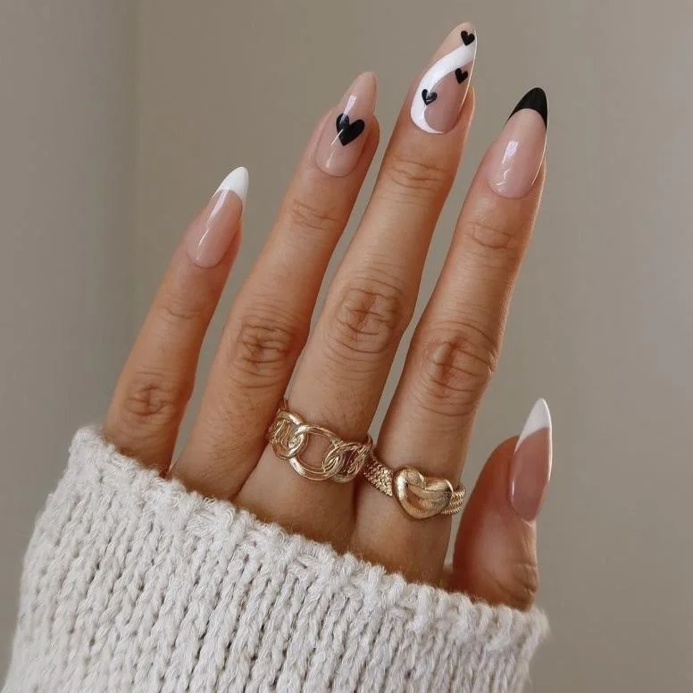 Minimalist nude nails with subtle black heart accents